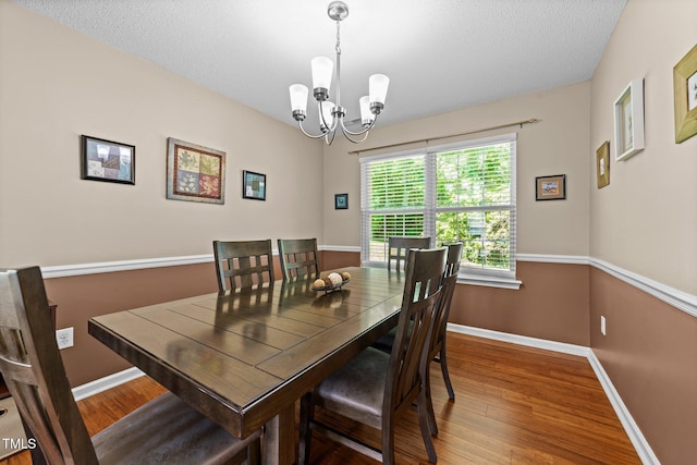 4221 Ivy Hill Rd, Raleigh, NC 27616 - dining room featuring a chandelier, wood finished floors, baseboards, and a textured ceiling