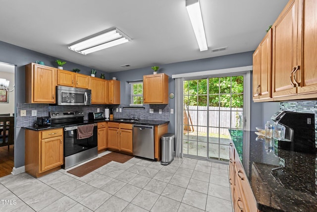 4221 Ivy Hill Rd, Raleigh, NC 27616 - kitchen featuring appliances with stainless steel finishes, tasteful backsplash, dark stone countertops, and light tile patterned floors