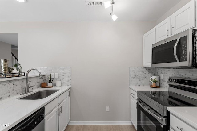 197 Scranton Ct, Cameron, NC 28326 - kitchen with stainless steel appliances, a sink, tasteful backsplash, light countertops, and white cabinetry