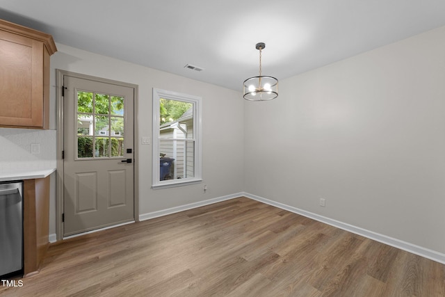 708 Powell Dr Unit B, Raleigh, NC 27606 - unfurnished dining area featuring light wood-style flooring, baseboards, and a chandelier