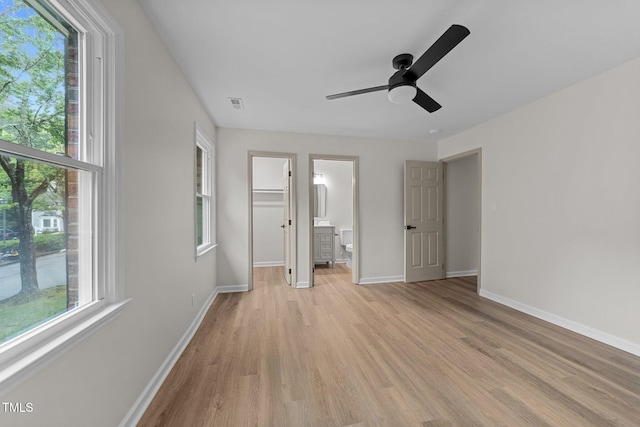 708 Powell Dr Unit B, Raleigh, NC 27606 - unfurnished bedroom with light wood finished floors, multiple windows, a spacious closet, and baseboards