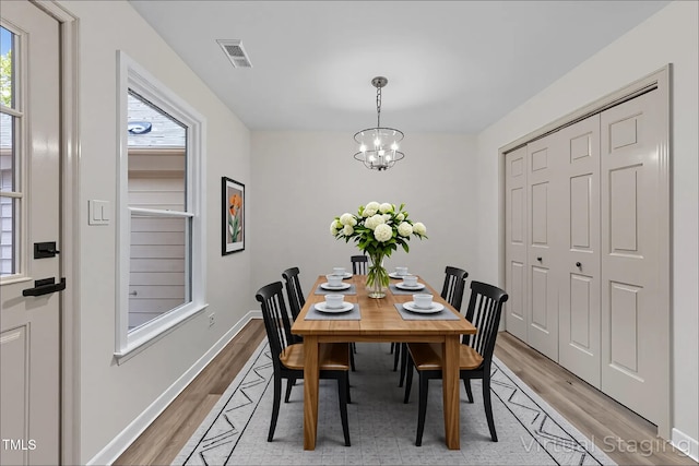 708 Powell Dr Unit B, Raleigh, NC 27606 - dining space with light wood-style floors, a chandelier, and baseboards