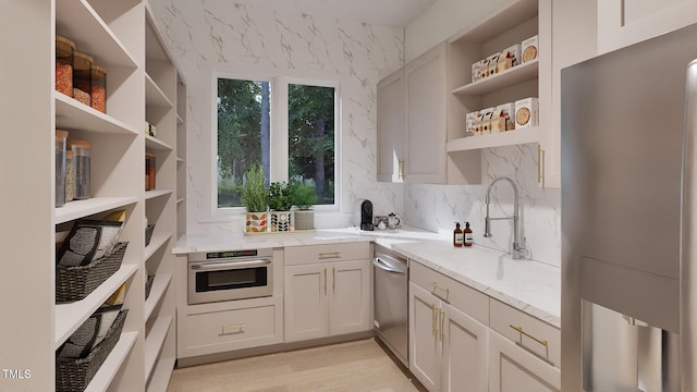 5013 Coronado, Raleigh, NC 27609 - kitchen with open shelves, appliances with stainless steel finishes, light stone counters, a sink, and light wood-style floors