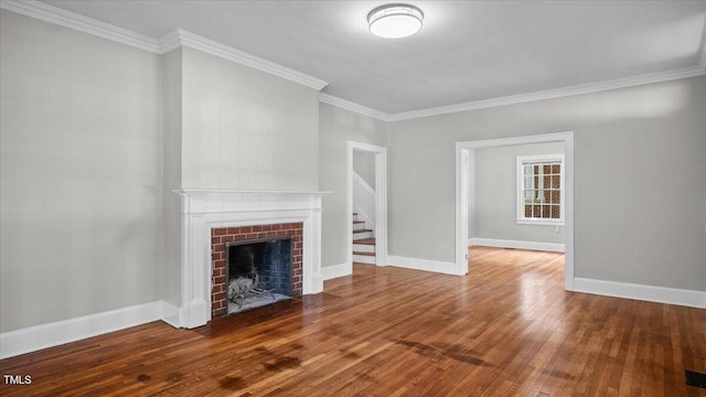 830 S Chestnut St, Henderson, NC 27536 - unfurnished living room featuring a brick fireplace, hardwood / wood-style flooring, crown molding, and baseboards