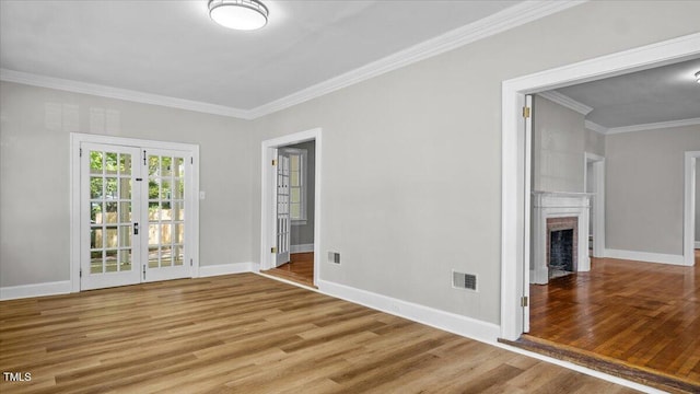 830 S Chestnut St, Henderson, NC 27536 - unfurnished room featuring wood finished floors, ornamental molding, french doors, a fireplace, and baseboards