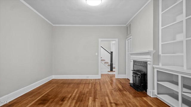 830 S Chestnut St, Henderson, NC 27536 - unfurnished living room with wood finished floors, baseboards, crown molding, stairway, and built in features