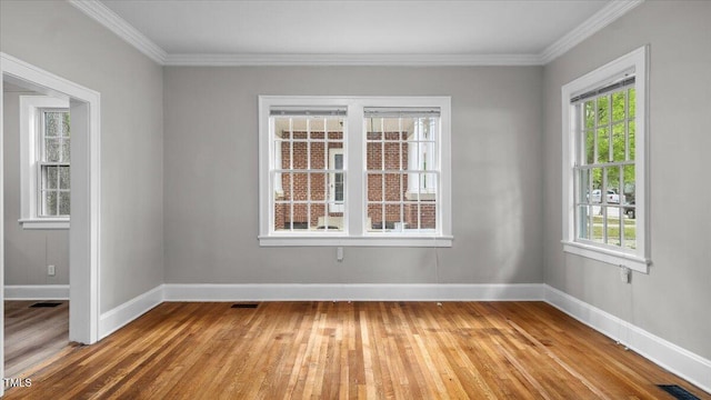 830 S Chestnut St, Henderson, NC 27536 - spare room featuring light wood-type flooring, plenty of natural light, baseboards, and crown molding