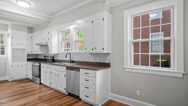 830 S Chestnut St, Henderson, NC 27536 - kitchen featuring appliances with stainless steel finishes, a sink, under cabinet range hood, dark countertops, and ornamental molding