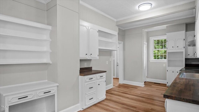 830 S Chestnut St, Henderson, NC 27536 - kitchen with open shelves, dark countertops, ornamental molding, white cabinetry, and baseboards
