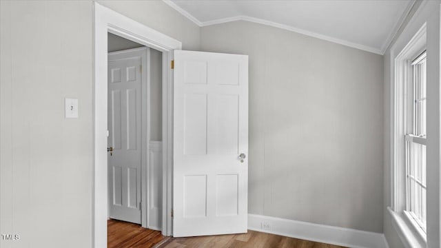 830 S Chestnut St, Henderson, NC 27536 - unfurnished bedroom with dark wood finished floors, ornamental molding, multiple windows, and baseboards