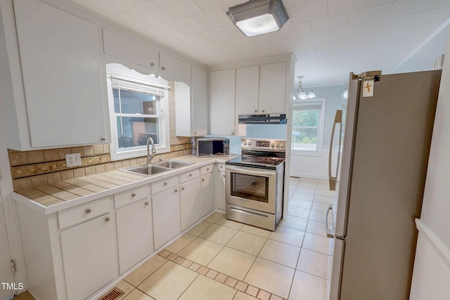 111 Dee Long Rd, Roxboro, NC 27574 - kitchen with stainless steel appliances, a sink, under cabinet range hood, backsplash, and white cabinets