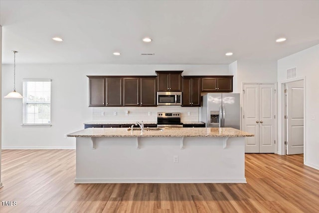 346 E Painted Way, Clayton, NC 27527 - kitchen with stainless steel appliances, dark brown cabinetry, backsplash, a breakfast bar area, and recessed lighting