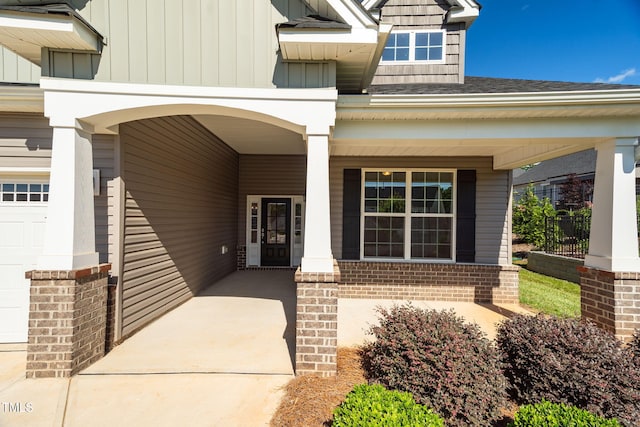1085 Lobdale Ct, Burlington, NC 27215 - property entrance featuring board and batten siding, brick siding, covered porch, and a shingled roof