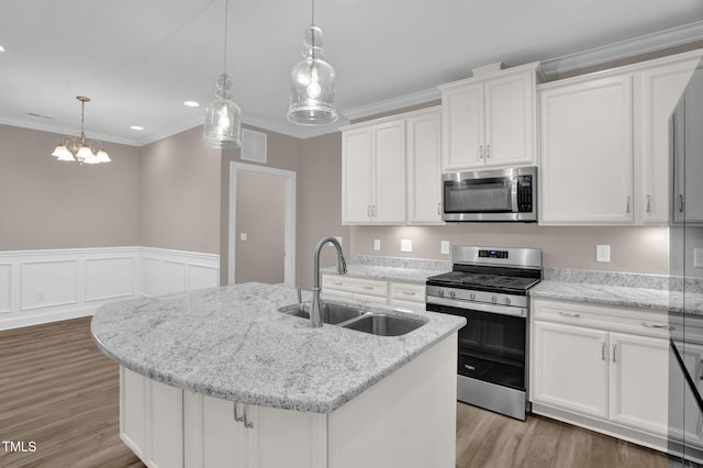 1085 Lobdale Ct, Burlington, NC 27215 - kitchen featuring appliances with stainless steel finishes, a sink, light wood finished floors, a center island with sink, and ornamental molding