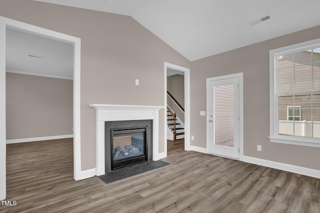 1085 Lobdale Ct, Burlington, NC 27215 - unfurnished living room featuring wood finished floors, lofted ceiling, baseboards, a fireplace with flush hearth, and stairs