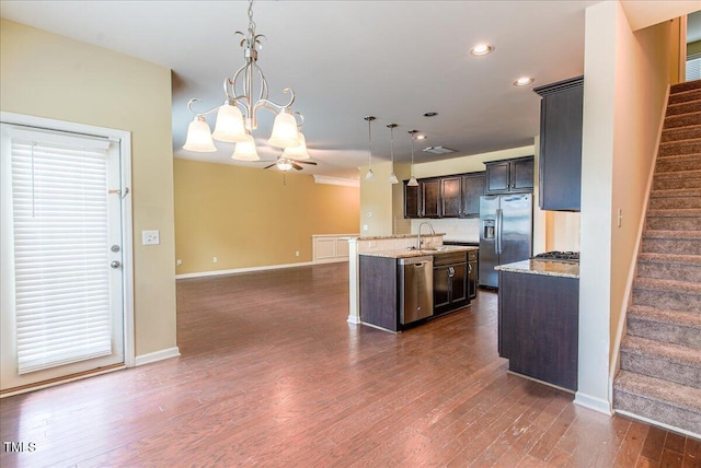 145 Torrey Heights Ln, Durham, NC 27703 - kitchen with stainless steel appliances, a center island with sink, a sink, dark brown cabinets, and recessed lighting