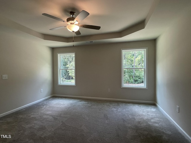 226 Bonsai Way, Four Oaks, NC 27524 - spare room featuring a tray ceiling, dark colored carpet, and ceiling fan