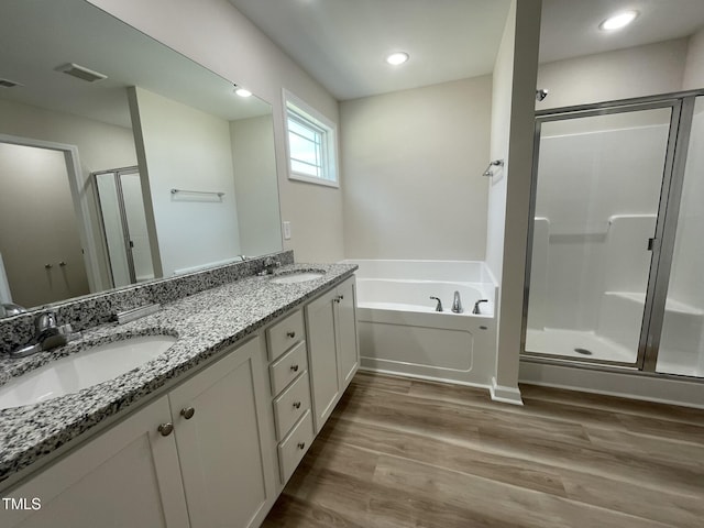 226 Bonsai Way, Four Oaks, NC 27524 - bathroom with a stall shower, double vanity, wood finished floors, a garden tub, and recessed lighting