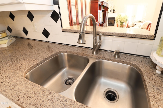 128 Olde Manor Ct, Siler City, NC 27344 - kitchen view of a sink, backsplash, a fireplace, and light stone counters