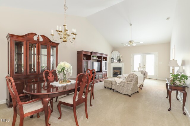 128 Olde Manor Ct, Siler City, NC 27344 - dining space with light carpet, a chandelier, a fireplace, high vaulted ceiling, and a ceiling fan