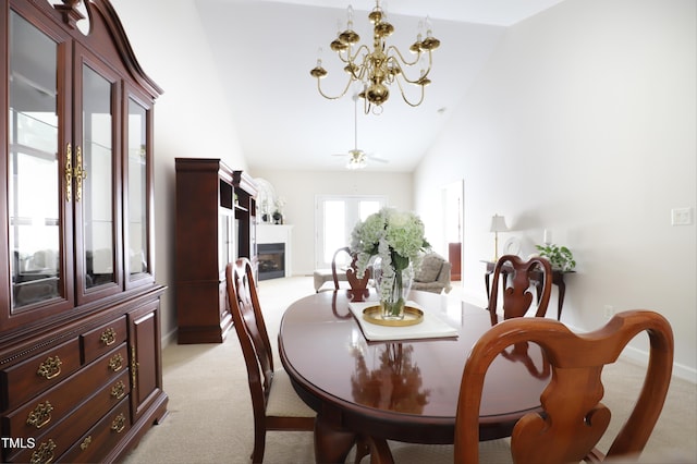 128 Olde Manor Ct, Siler City, NC 27344 - dining area featuring a chandelier, light colored carpet, a fireplace, high vaulted ceiling, and baseboards