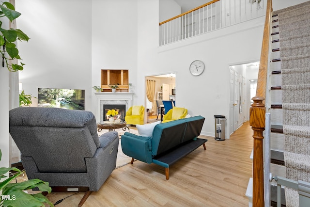 4705 Royal Troon Dr, Raleigh, NC 27604 - living area with light wood-type flooring, a premium fireplace, a high ceiling, baseboards, and stairway