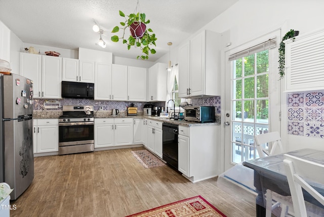 4705 Royal Troon Dr, Raleigh, NC 27604 - kitchen with black appliances, light wood-style floors, backsplash, white cabinets, and a sink