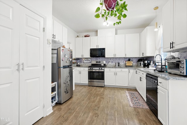 4705 Royal Troon Dr, Raleigh, NC 27604 - kitchen with black appliances, a sink, light wood-type flooring, and white cabinetry