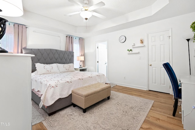 4705 Royal Troon Dr, Raleigh, NC 27604 - bedroom featuring a tray ceiling, wood finished floors, baseboards, and a ceiling fan
