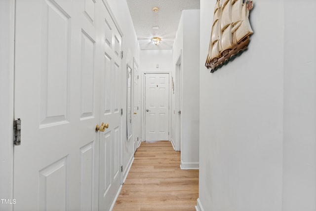 4705 Royal Troon Dr, Raleigh, NC 27604 - hallway featuring light wood-style flooring, a textured ceiling, and baseboards