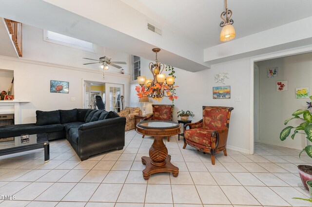 103 Pony Express Cv, Louisburg, NC 27549 - living room featuring light tile patterned floors, ceiling fan, a chandelier, baseboards, and a fireplace