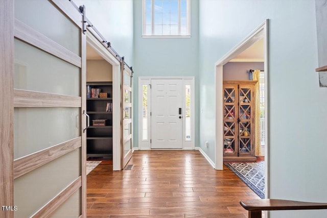947 Middle Ground Ave, Rolesville, NC 27571 - foyer entrance with a barn door, hardwood / wood-style flooring, a towering ceiling, and baseboards