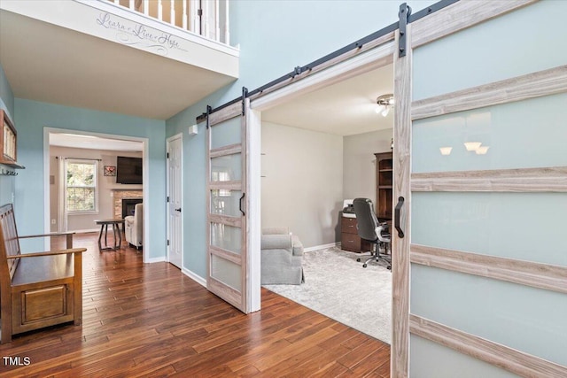 947 Middle Ground Ave, Rolesville, NC 27571 - entryway featuring a barn door, wood finished floors, baseboards, and a fireplace