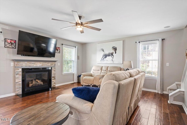 947 Middle Ground Ave, Rolesville, NC 27571 - living room featuring a ceiling fan, baseboards, dark wood-style flooring, and a stone fireplace