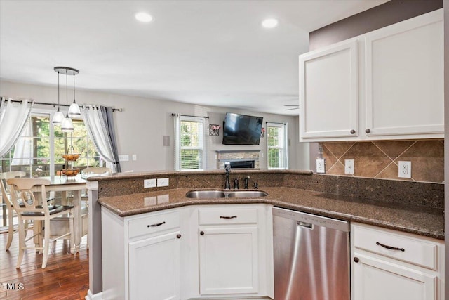 947 Middle Ground Ave, Rolesville, NC 27571 - kitchen featuring dishwasher, a sink, a peninsula, dark stone counters, and white cabinetry