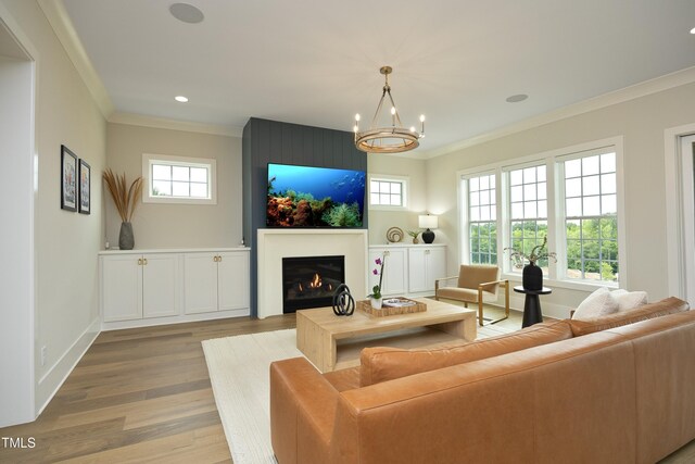 7736 Roberts Rd, Apex, NC 27523 - living room with crown molding, wood finished floors, a lit fireplace, a chandelier, and recessed lighting