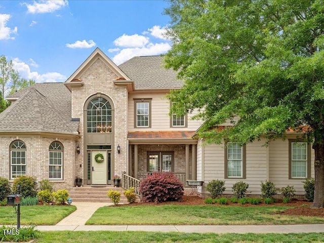 2207 Cameron Pond Dr, Cary, NC 27519 - view of front of home with brick siding, a shingled roof, and a front lawn