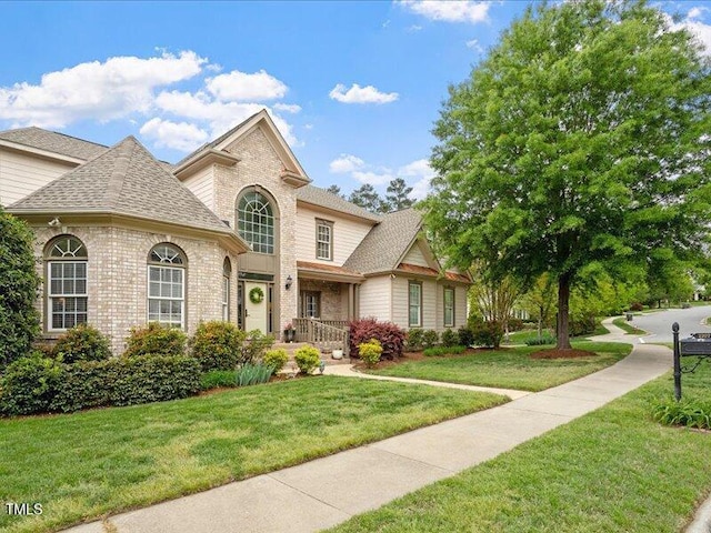 2207 Cameron Pond Dr, Cary, NC 27519 - view of front of home with a front lawn, brick siding, and roof with shingles