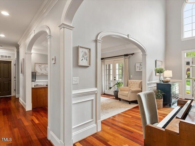 2207 Cameron Pond Dr, Cary, NC 27519 - hall featuring decorative columns, arched walkways, wood finished floors, crown molding, and healthy amount of natural light