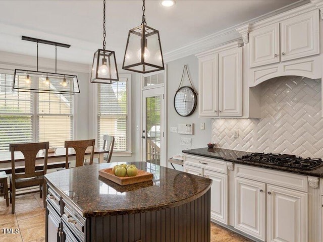 2207 Cameron Pond Dr, Cary, NC 27519 - kitchen featuring black gas stovetop, tasteful backsplash, white cabinets, a kitchen island, and dark stone counters