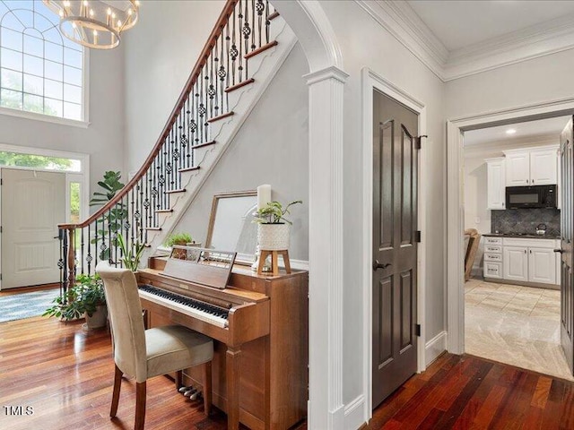 2207 Cameron Pond Dr, Cary, NC 27519 - foyer entrance with a chandelier, wood finished floors, stairs, crown molding, and a towering ceiling