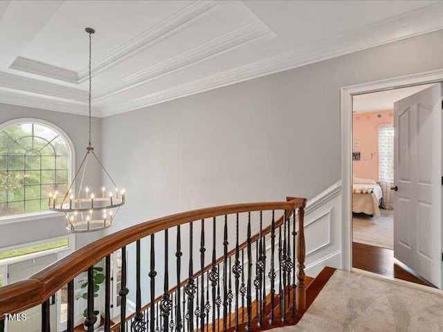 2207 Cameron Pond Dr, Cary, NC 27519 - hall featuring a chandelier, ornamental molding, a tray ceiling, an upstairs landing, and wainscoting