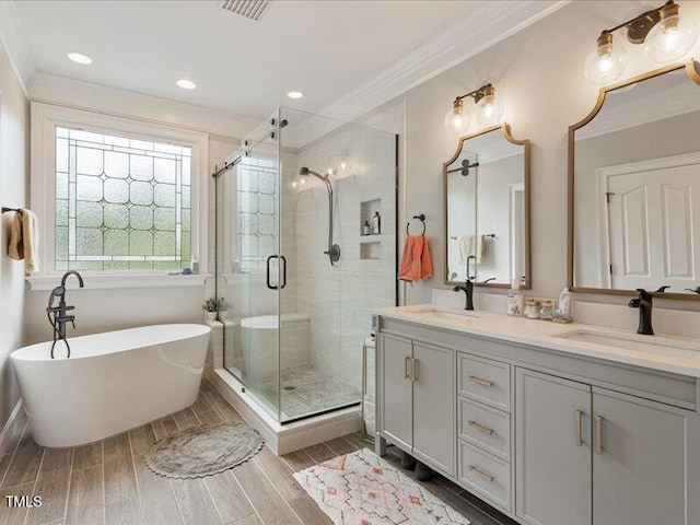 2207 Cameron Pond Dr, Cary, NC 27519 - full bathroom with crown molding, double vanity, a stall shower, a soaking tub, and wood finished floors