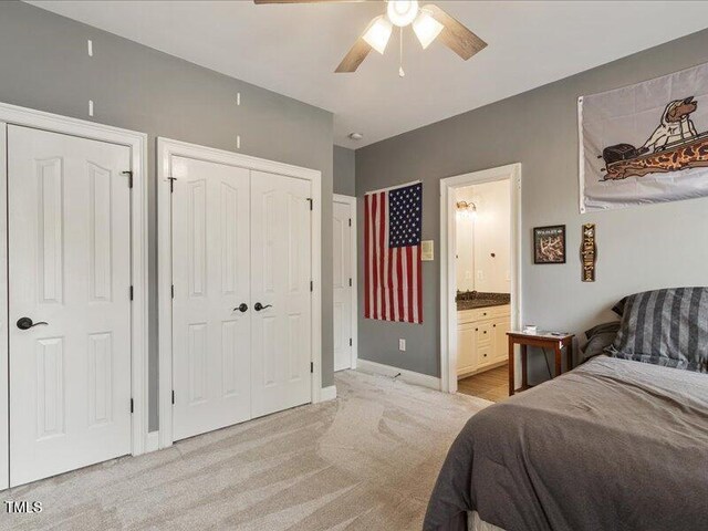 2207 Cameron Pond Dr, Cary, NC 27519 - bedroom featuring light carpet, baseboards, ceiling fan, ensuite bathroom, and multiple closets