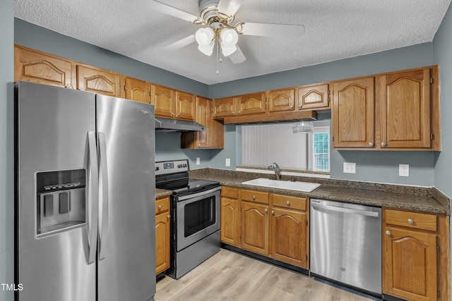 4658 Fawnbrook Cir, Raleigh, NC 27612 - kitchen with stainless steel appliances, a sink, under cabinet range hood, dark countertops, and a textured ceiling