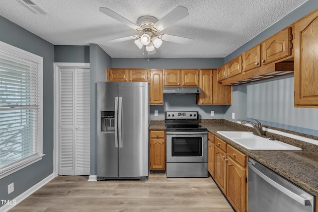 4658 Fawnbrook Cir, Raleigh, NC 27612 - kitchen with stainless steel appliances, under cabinet range hood, healthy amount of natural light, a sink, and a textured ceiling