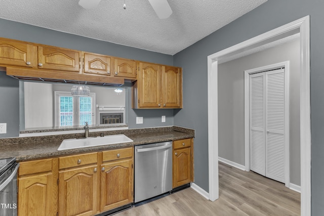 4658 Fawnbrook Cir, Raleigh, NC 27612 - kitchen with appliances with stainless steel finishes, a sink, dark countertops, light wood-type flooring, and a ceiling fan