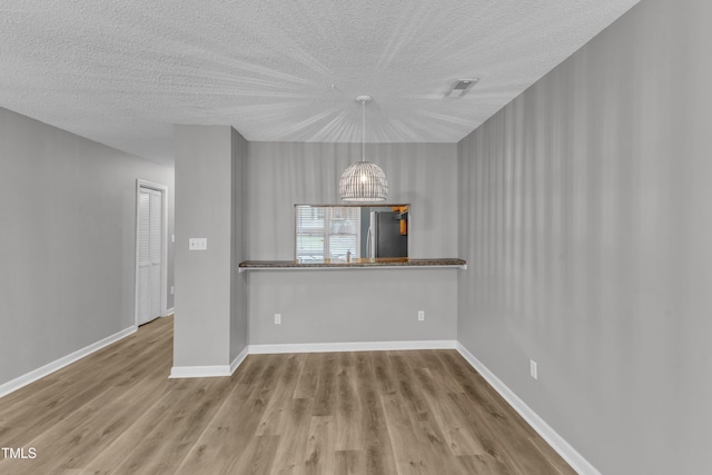 4658 Fawnbrook Cir, Raleigh, NC 27612 - unfurnished dining area featuring a textured ceiling, wood finished floors, a chandelier, and baseboards