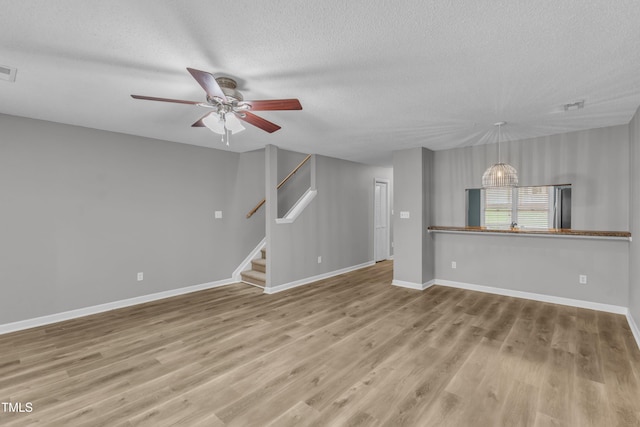 4658 Fawnbrook Cir, Raleigh, NC 27612 - unfurnished room featuring a textured ceiling, ceiling fan, wood finished floors, stairs, and baseboards