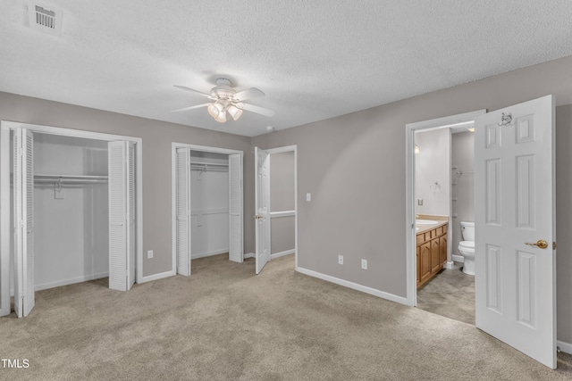 4658 Fawnbrook Cir, Raleigh, NC 27612 - unfurnished bedroom featuring multiple closets, light carpet, baseboards, a textured ceiling, and ensuite bathroom